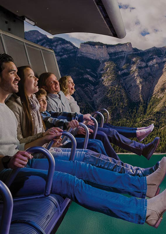 A group of people on the FlyOver experience with Lake Minnewanka in the background.