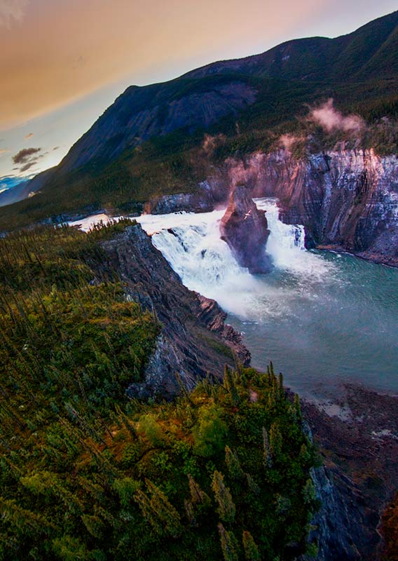 An aerial view of a waterfall rushing between mountainous terrain